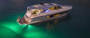 Riviera 6800 Sport Yacht with underwater lights on at anchor