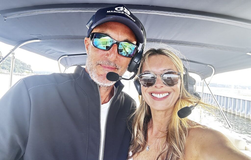Man and woman one boat's flybridge wearing communication headsets